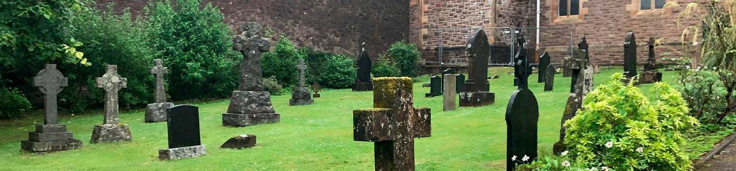 Vista de tumbas cubiertas de musgo en un cementerio en Fort Williams, en Highlands, Escocia