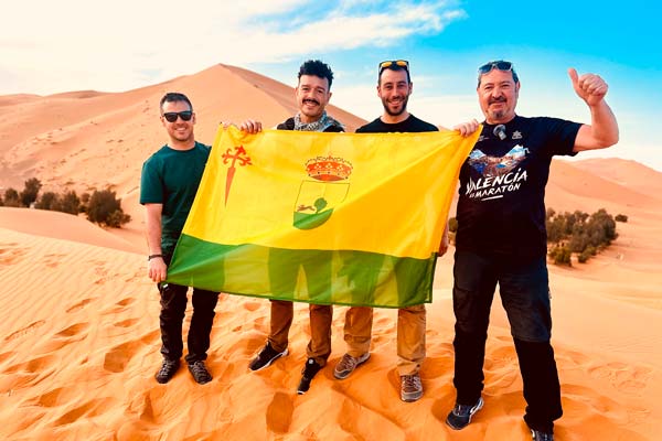 El grupo con la bandera de Tomelloso en las dunas del Desierto del Sáhara