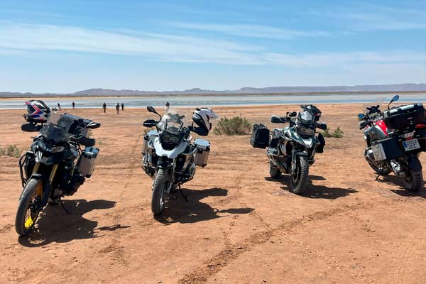 Las cuatro motos del grupo con el lago en Merzouga, Desierto del Sáhara, Marruecos